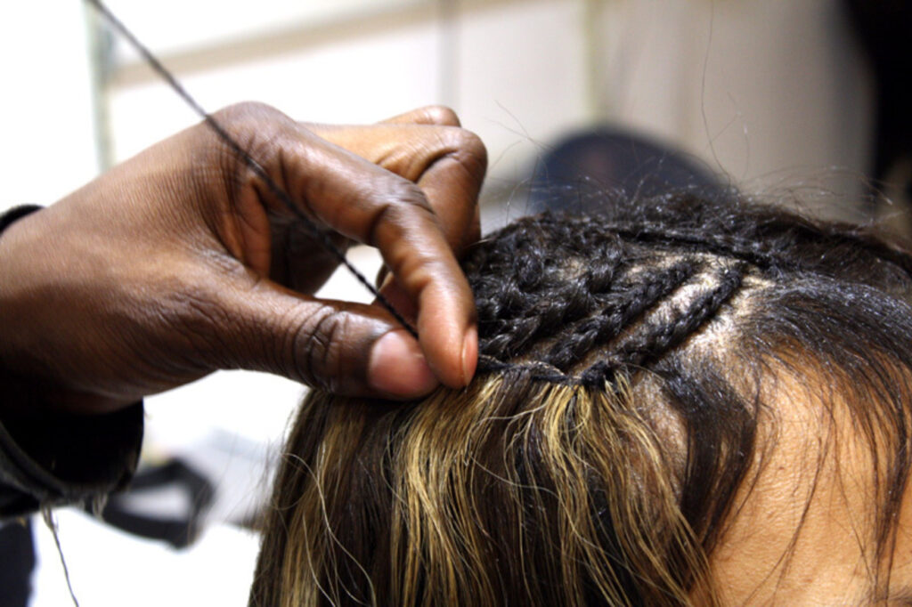 Image of lady having weave-on made for her. Showcasing one of the many hair styles, WeaveBraidsDirect had expertise in.